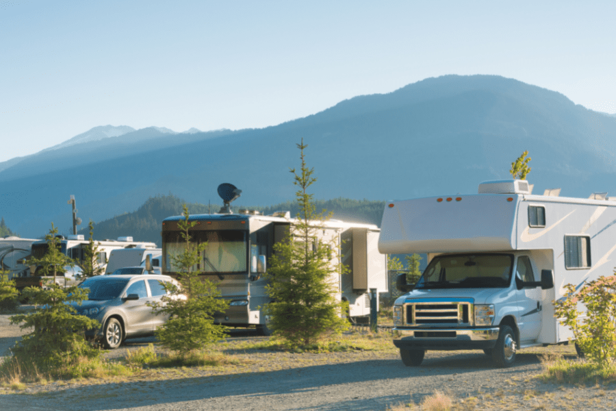 RV parked in dusty field with mountain in background