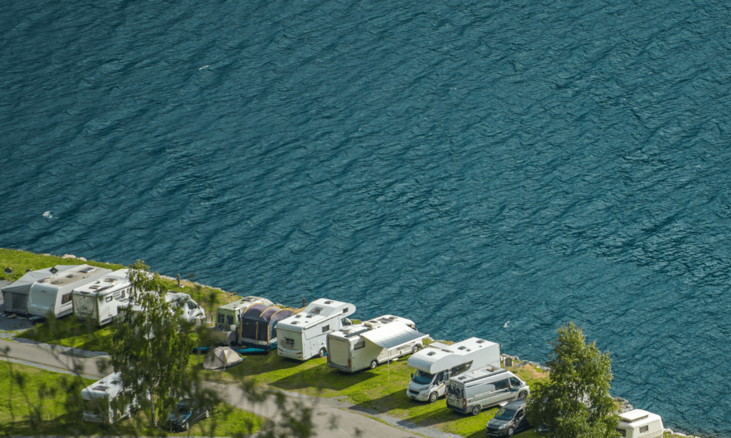 RV's parked next to coast of large body of water