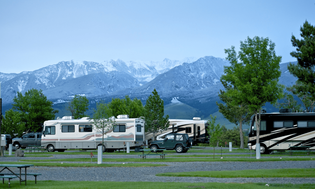 RV's parked in camp with snow capped mountains in back groun